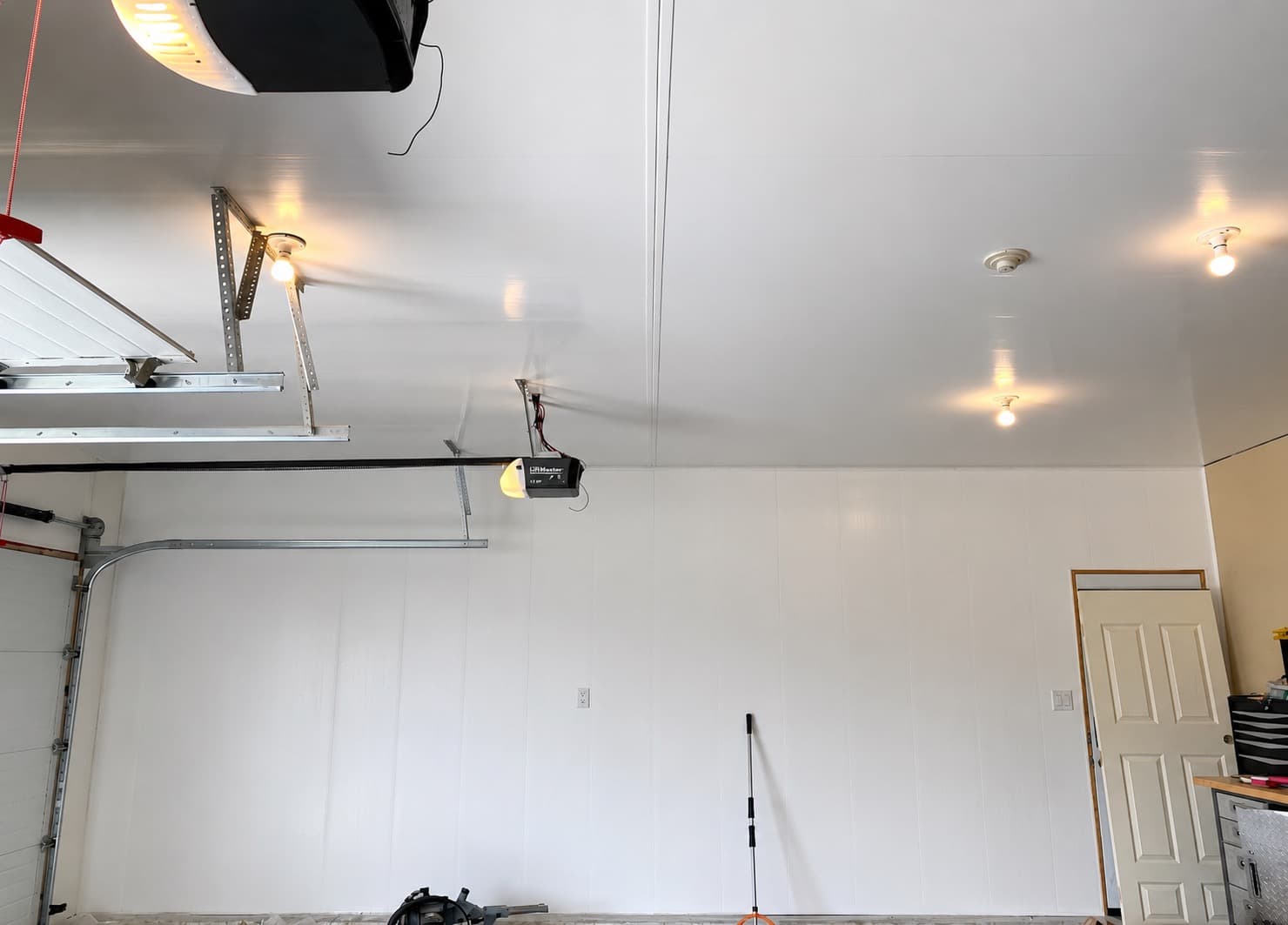 Finished custom garage interior with ceiling panels and garage doors