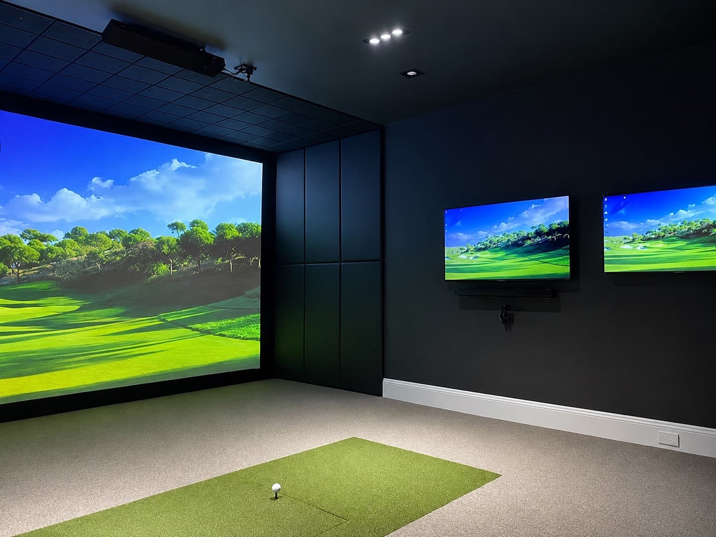Custom indoor golf simulator room with projector screen and practice mat
